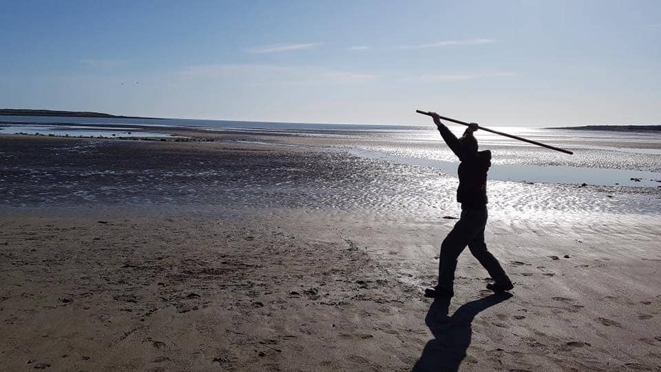 man training martial arts on beach